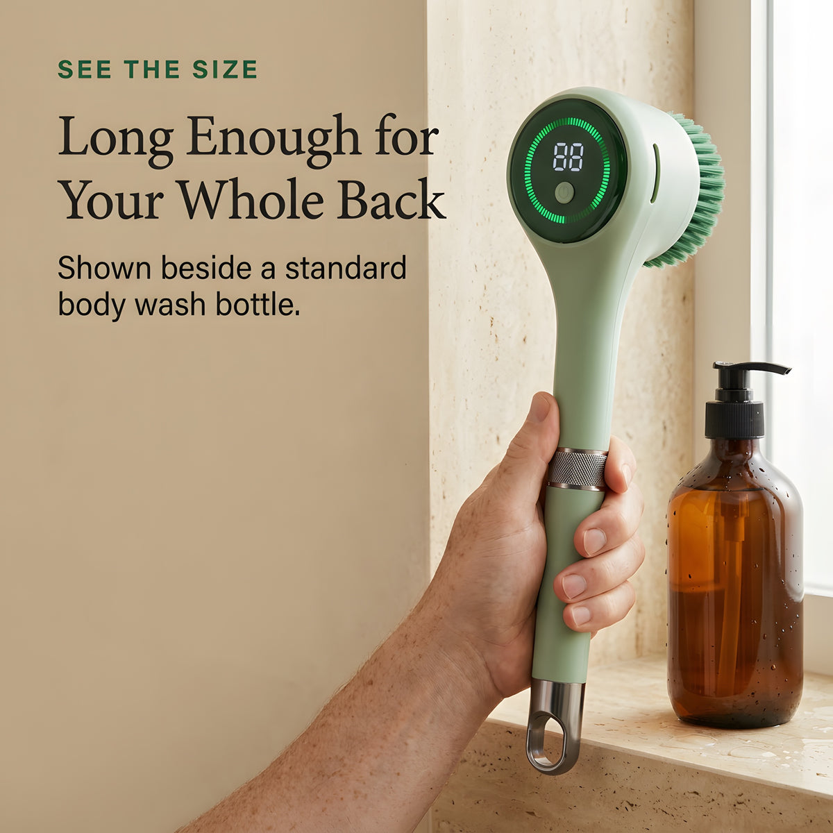 Hand holding the electric scrubber beside a standard body wash bottle to show its real length