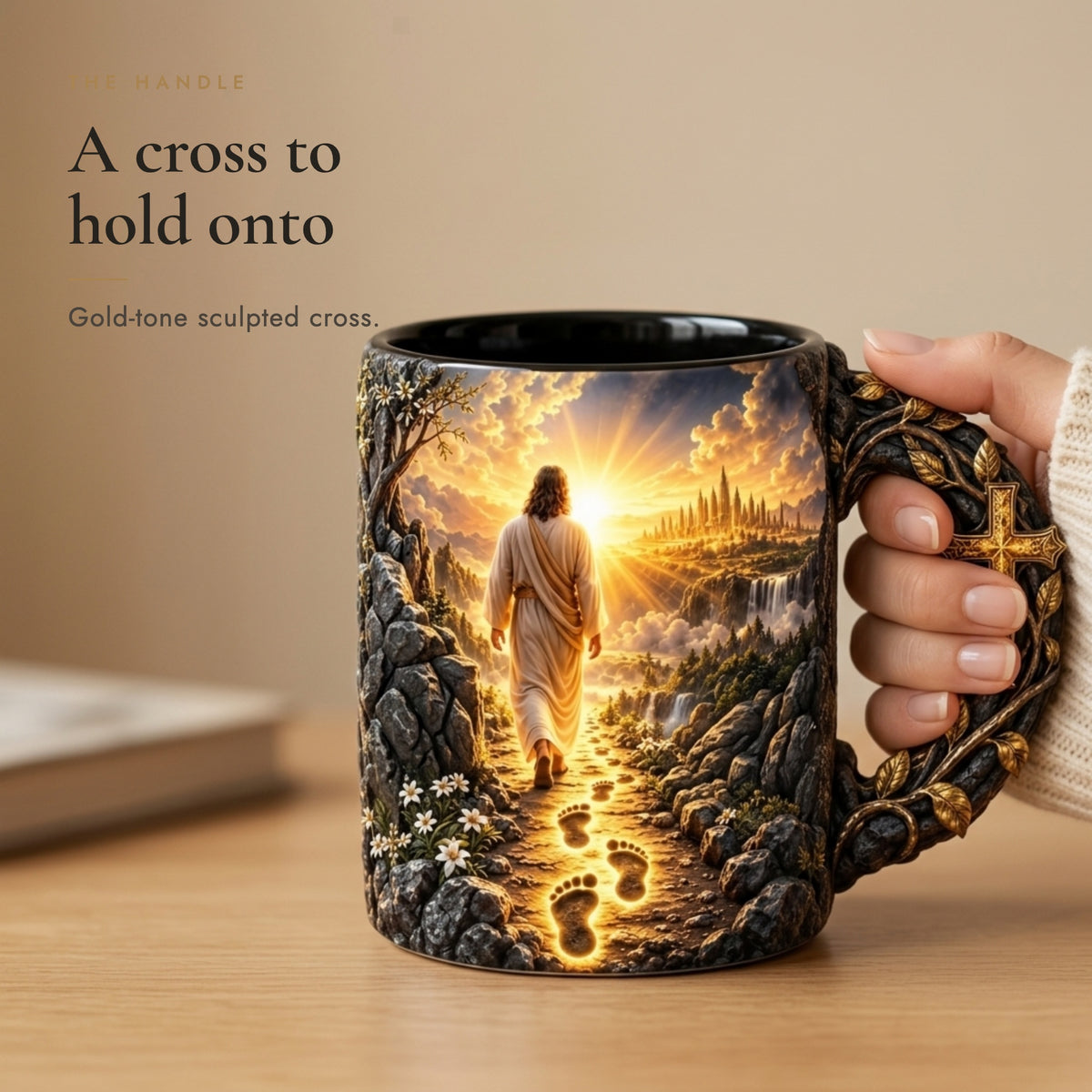 Hand holding the Footprints of Grace mug by its gold-tone sculpted cross handle